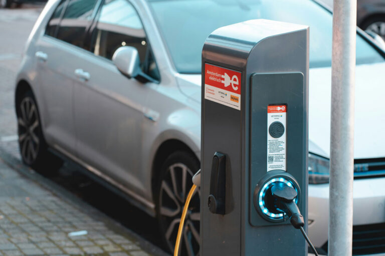 Electric car plugged into an Amsterdam street charging station with glowing connector