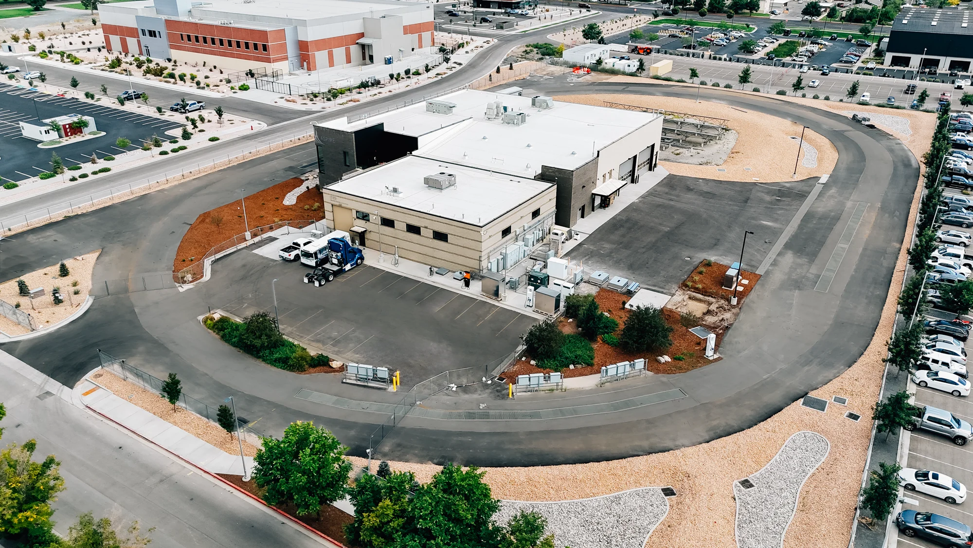Aerial view of the EVR Electric Vehicle and Roadway building encircled by a test track and parking